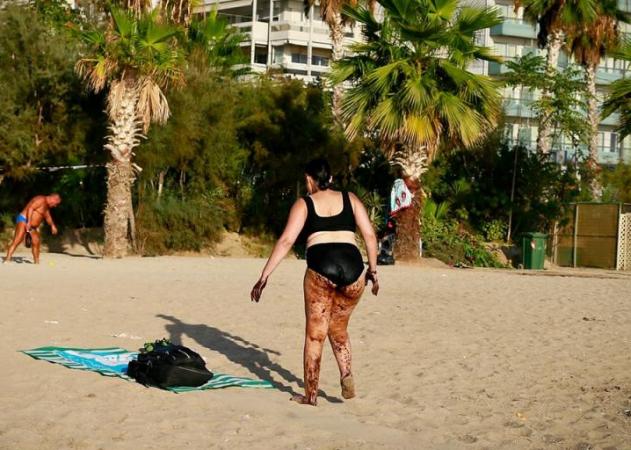 Σοκαριστική φωτογραφία από το Παλαιό Φάληρο: Γυναίκα βγαίνει από τη θάλασσα, καλυμμένη με πίσσα!